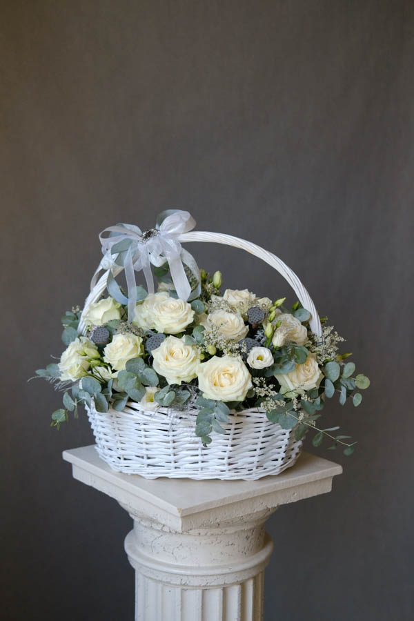 Плетеная корзина с белыми розами коробочками лотоса и эустомой 1